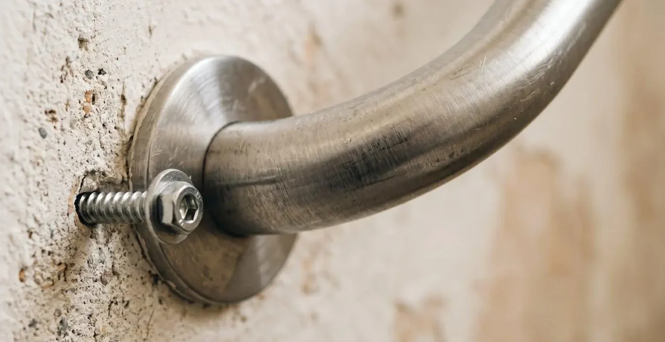 Gros plan sur une barre d'appui métallique moderne fixée au mur d'un couloir résidentiel