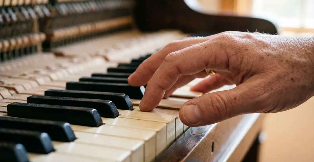 Gros plan sur les mains d'un adulte posées sur un clavier de piano, symbolisant l'apprentissage tardif et la persévérance
