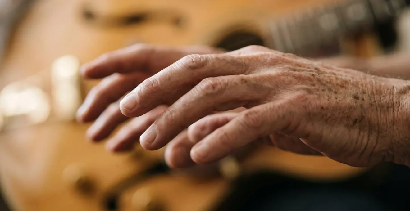 Mains d'une personne âgée en position de jeu instrumental illustrant la coordination motrice fine