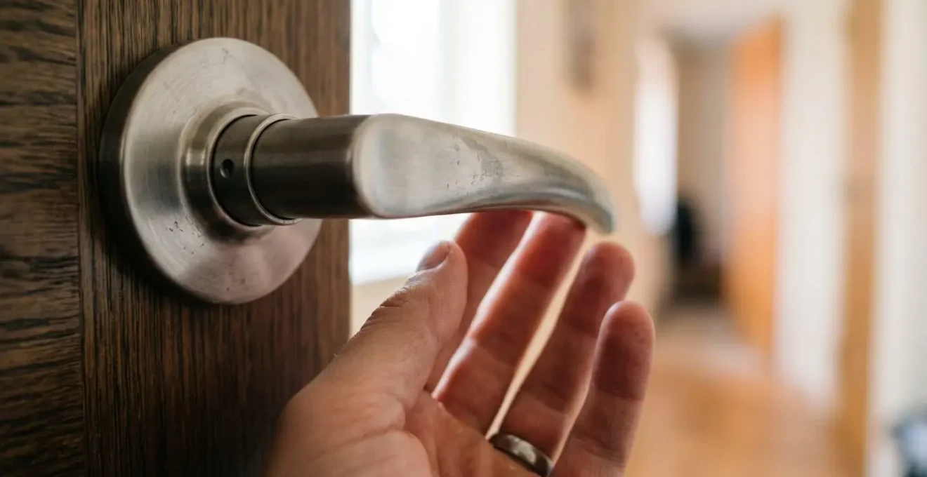 Gros plan sur une poignée de porte en forme de bec de cane installée à hauteur accessible